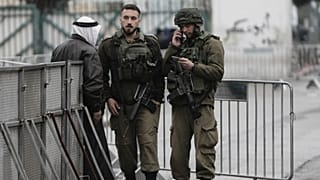 جنود إسرائيليون يدققون في هوية فلسطيني عند أحد الحواجز في بيت لحم أثناء توجهه إلى المسجد الأقصى لأداء أول صلاة جمعة من شهر رمضان، في 7 مارس 2025.