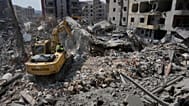 عمال الإنقاذ يستخدمون حفارة أثناء بحثهم عن الضحايا تحت أنقاض مبنى تعرض لغارة جوية إسرائيلية يوم الاثنين في مدينة صور الساحلية الجنوبية بلبنان، الثلاثاء 2 يونيو 2026. 