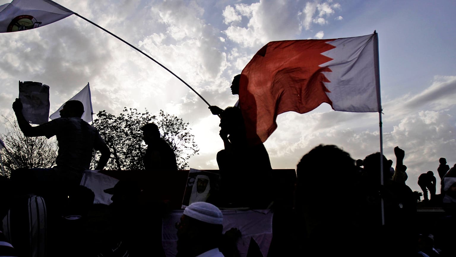 يرافق المشيعون الذين يلوحون بالأعلام الوطنية وأعلام المعارضة نعش متظاهر مناهض للحكومة قُتل خلال عطلة نهاية الأسبوع خلال جنازته المشحونة سياسياً يوم الاثنين 23 أبريل 2012 