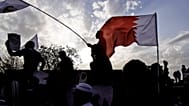 يرافق المشيعون الذين يلوحون بالأعلام الوطنية وأعلام المعارضة نعش متظاهر مناهض للحكومة قُتل خلال عطلة نهاية الأسبوع خلال جنازته المشحونة سياسياً يوم الاثنين 23 أبريل 2012 
