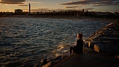 ARCHIV: Eine Frau sitzt auf einer Mole am Mittelmeer in Barcelona, Spanien, am Dienstag, den dritten Februar 2026. (Foto: AP/Emilio Morenatti)