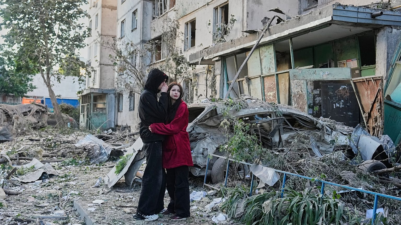 Persone reagiscono mentre osservano il luogo di un attacco missilistico russo che ha colpito un edificio residenziale a Kiev, Ucraina, martedì 2 giugno 2026.