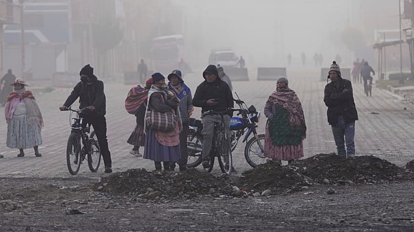 Residentes observan a la Policía retirar las barricadas levantadas por manifestantes antigubernamentales en una carretera de El Alto, Bolivia, el 23 de mayo de 2026. 