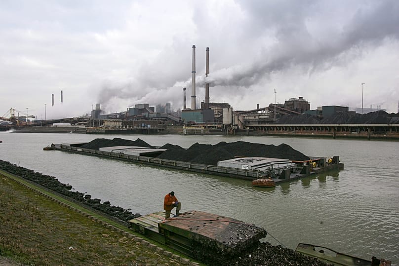 A worker is seen on a pontoon near the former Corus, and current Tata steel factory, background, in IJmuiden, Netherlands, on Tuesday Jan. 30, 2007.