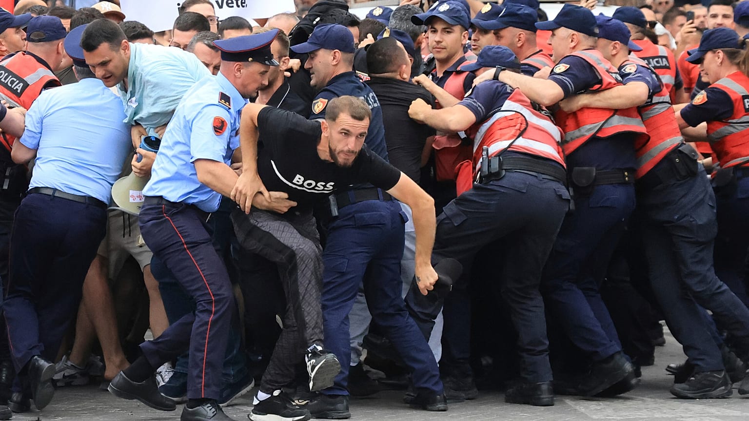 Protesters scuffle with police officers blocking a street during a demonstration in Tirana