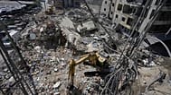 Rescue worker searches for victims under the rubble of a building that was hit Monday in an Israeli strike in the southern city of Tyre, 2 June, 2026