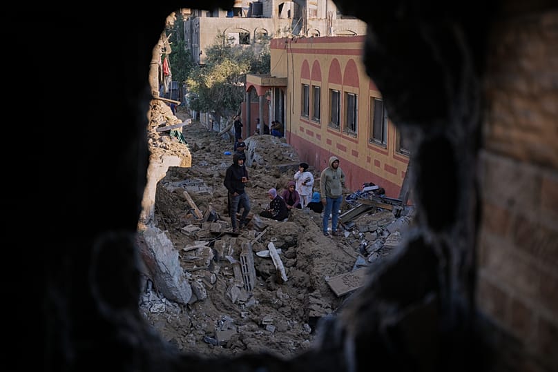  فلسطينيون يتفقدون أنقاض مبنى دمره غارة إسرائيلية في دير البلح، وسط قطاع غزة، يوم الجمعة 29 مايو/أيار 2026