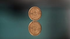 ARŞİV - Çekya'nın Prag kentinde fotoğraf için bir Bitcoin jetonu aynanın üzerine yerleştiriliyor. 11 Mayıs 2025.