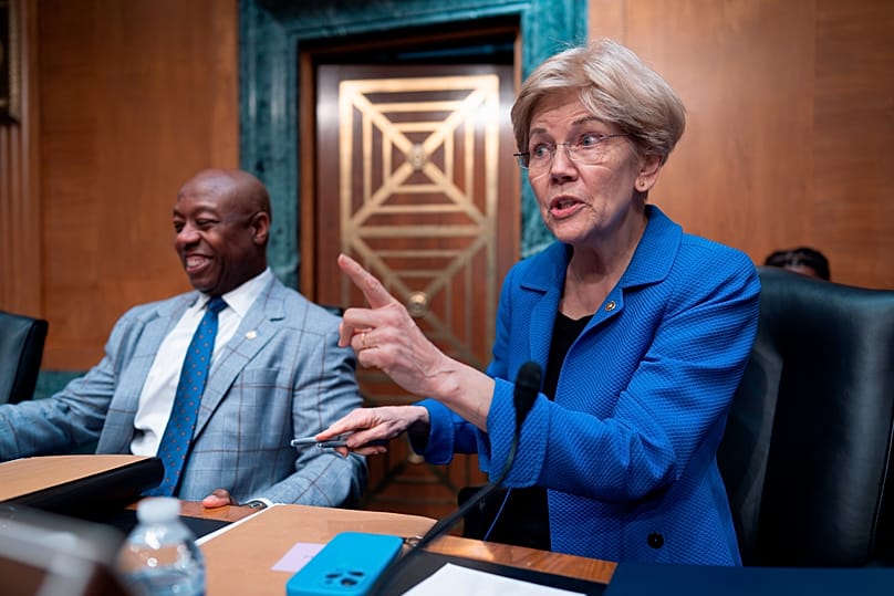 O presidente da Comissão Bancária do Senado dos EUA, Tim Scott, e a senadora Elizabeth Warren tomam os seus lugares antes de uma audição, Washington, 29 de abril de 2026