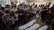 Enlutados rezam junto aos corpos de palestinianos mortos num ataque israelita, durante o funeral no Hospital Shifa