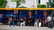 People wait at a bus station displaying election posters in capital Pristina, 5 June, 2026