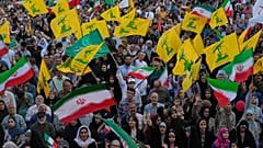 پرچم‌های ایران و حزب‌الله در دست شرکت کنندگان در اجتماعی مذهبی در تهران