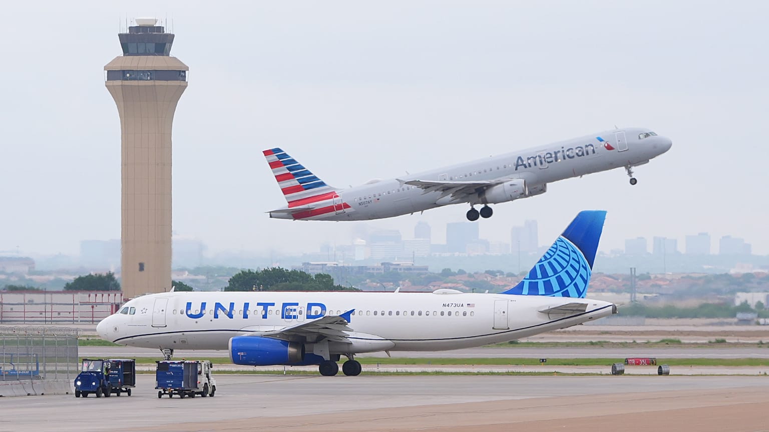 An American Airlines jet takes off as an United Airlines jet taxis at DFW International Airport in Grapevine, Texas, Tuesday, April 14, 2026..
