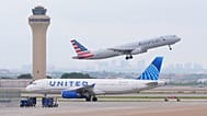 An American Airlines jet takes off as an United Airlines jet taxis at DFW International Airport in Grapevine, Texas, Tuesday, April 14, 2026..