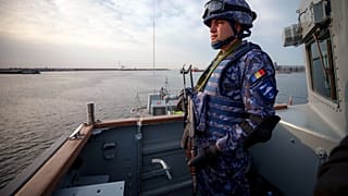 A Romanian naval serviceman guards onboard the M-270 Mine-hunter during a Romanian Navy led exercise outside Constanta, Romania, Tuesday, April 16, 2024.