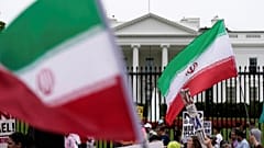 رفع المتظاهرون لافتات ولوّحوا بالعلم الإيراني أثناء تجمعهم أمام البيت الأبيض، يوم الأحد 22 يونيو/حزيران 2025، في واشنطن