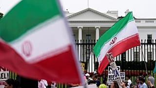 رفع المتظاهرون لافتات ولوّحوا بالعلم الإيراني أثناء تجمعهم أمام البيت الأبيض، يوم الأحد 22 يونيو/حزيران 2025، في واشنطن