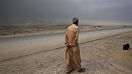 رجل يسير على طريق في القيارة، على بعد حوالي 50 كيلومترا جنوب الموصل، العراق، الأربعاء 26 أكتوبر 2016.