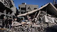فلسطينيون يتفقدون أنقاض مبنى دمره قصف إسرائيلي في الزوايدة وسط قطاع غزة، الجمعة 5 يونيو/حزيران 2026.