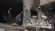 Residents and workers clear debris from an apartment building damaged in an Israeli airstrike a day earlier in Choueifat, in Dahiyeh, Beirut's southern suburbs, Lebanon, Frida