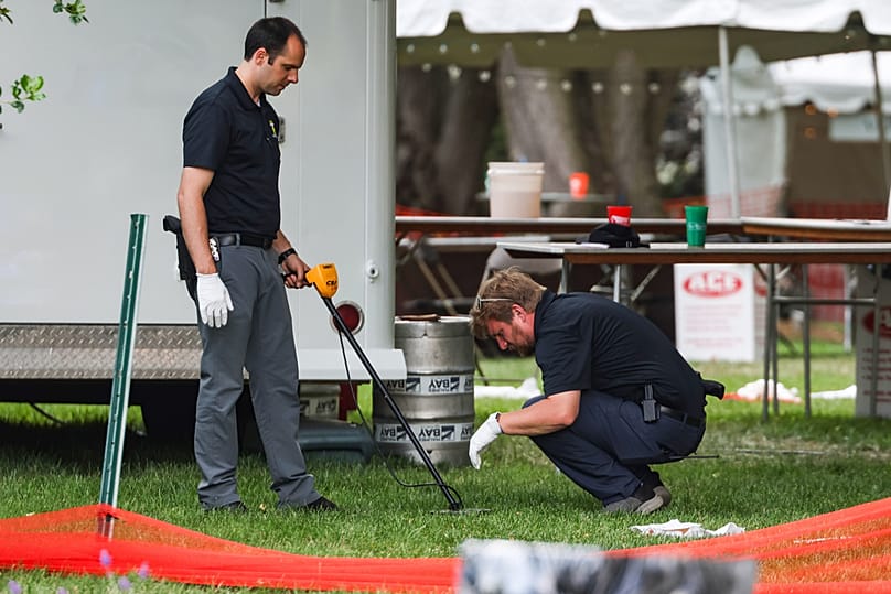 Investigators use metal detector to look for shells after a shooting that left 12 people injured at the Old West End Festival in Toledo, Ohio on Saturday, June 6, 2026