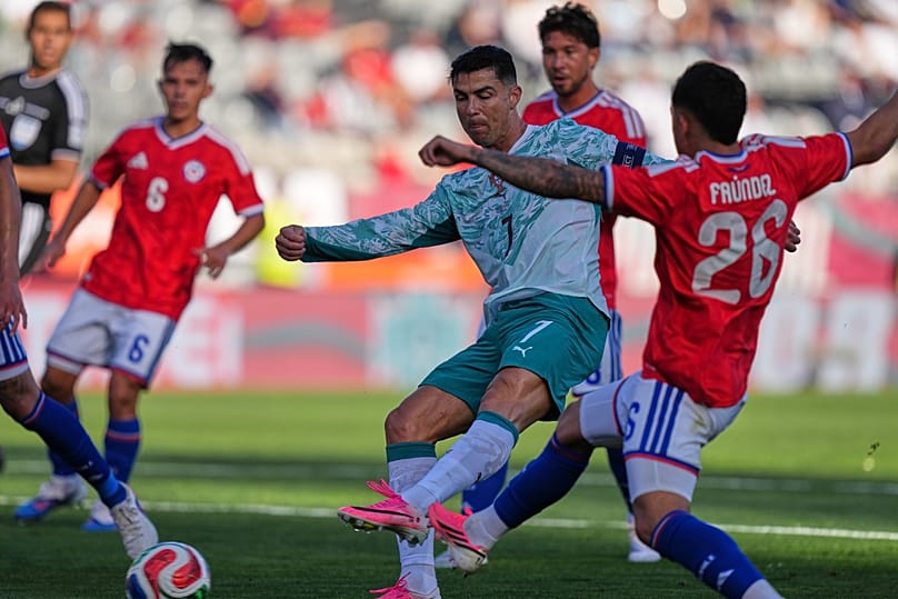 Cristiano Ronaldo, de Portugal, ao centro, e Felipe Faundez, do Chile, disputam a bola durante um jogo de futebol de amigável internacional
