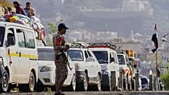 مقاتل حوثي يقف عند نقطة تفتيش لإدارة صف السيارات المغادرة من المدينة باتجاه المناطق التي يسيطر عليها الحوثيون عبر الممر الشرقي ، قبل عيد الأضحى الإسلامي، في تعز، اليمن،