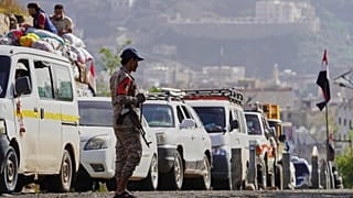 مقاتل حوثي يقف عند نقطة تفتيش لإدارة صف السيارات المغادرة من المدينة باتجاه المناطق التي يسيطر عليها الحوثيون عبر الممر الشرقي ، قبل عيد الأضحى الإسلامي، في تعز، اليمن،