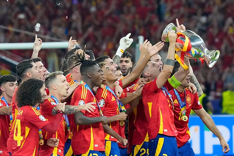 Spanyol játékosok ünnepelnek a 2024-es labdarúgó Európa-bajnokság győztesének járó trófeával az Anglia elleni döntő után Berlinben, 2024. július 14-én