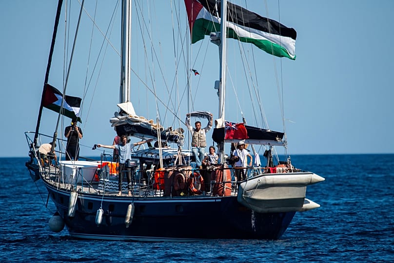 نشطاء من "ائتلاف أسطول الحرية" على متن سفينة "مادلين" قبيل إبحارها نحو غزة من ميناء كاتانيا في صقلية الإيطالية، في 1 يونيو 2025.
