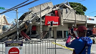 Residents takes a picture of a collapsed structure following an earthquake in General Santos, 8 June, 2026