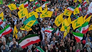 يرفع مشاركون أعلام إيران وحزب الله خلال مهرجان في طهران، الخميس 4 يونيو/حزيران 2026.
