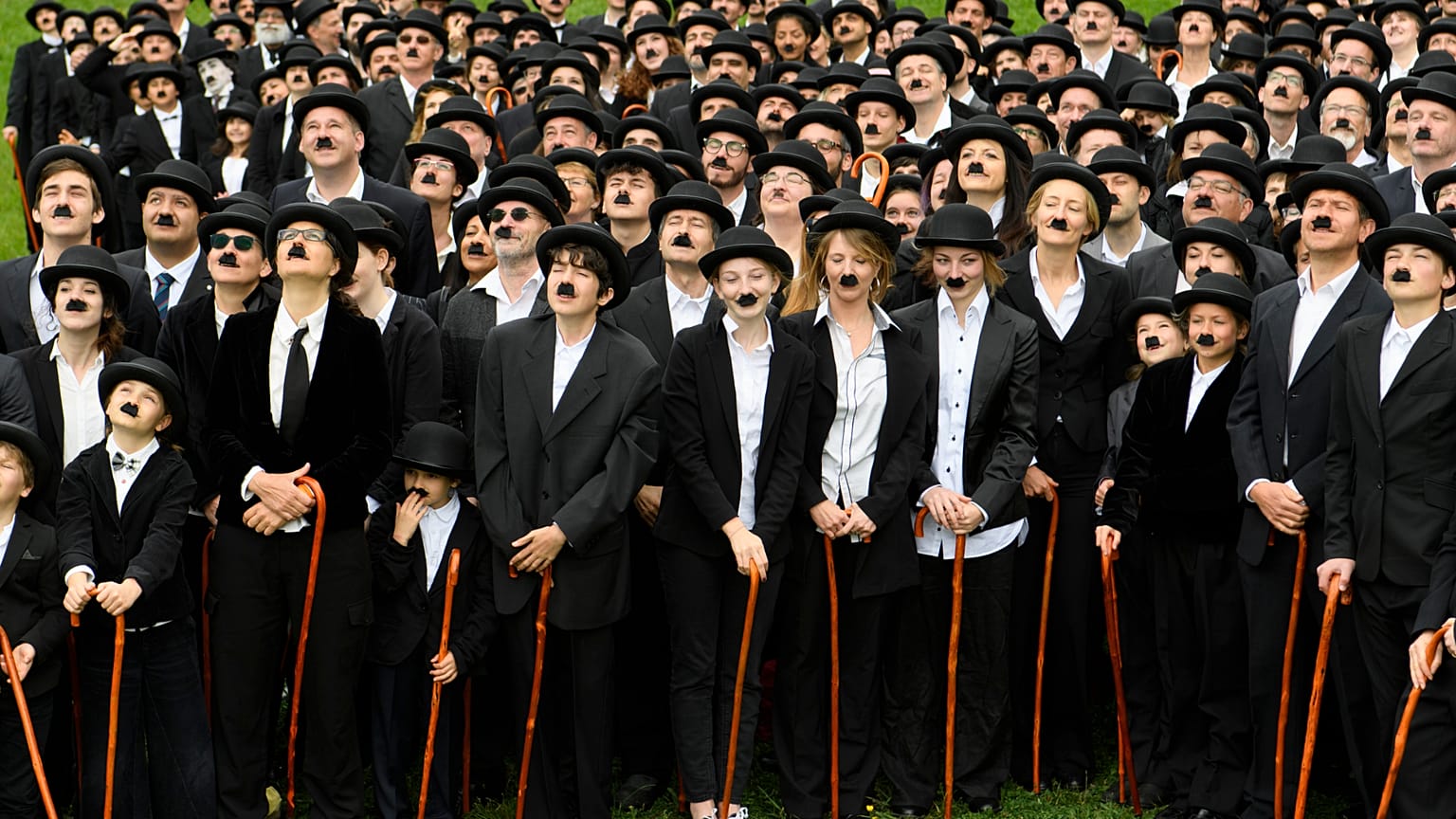 Participantes disfrazados del célebre Vagabundo de Charlie Chaplin posan frente a la antigua residencia de Chaplin en Suiza.