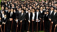 Participantes disfrazados del célebre Vagabundo de Charlie Chaplin posan frente a la antigua residencia de Chaplin en Suiza.