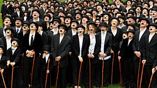 Participants dressed as Charlie Chaplin's famous Tramp character pose outside Chaplin's former home in Switzerland.