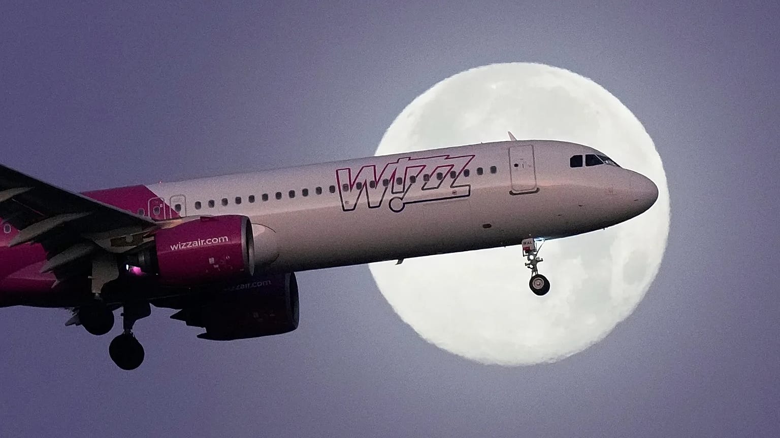 FILE - A Wizz Air Airbus A321 approaches for landing in Lisbon with the full moon in the background. Dec. 16, 2024. (AP Photo/Armando Franca)