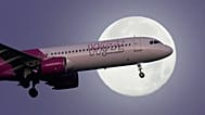 ZDJĘCIE ARCHIWALNE – samolot Airbus A321 linii Wizz Air podchodzi do lądowania w Lizbonie na tle pełni księżyca, 16 grudnia 2024. (AP Photo/Armando Franca)