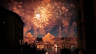 Фейерверк над Женевским озером озаряет ночь во время праздника Fête de Genève, фестиваля Женевы, в Женеве, Швейцария.