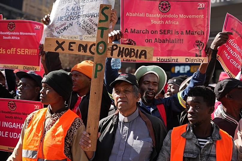 A pastor holds a wooden cross during an anti-xenophobia march in Johannesburg, South Africa, Thursday, July 17, 2025