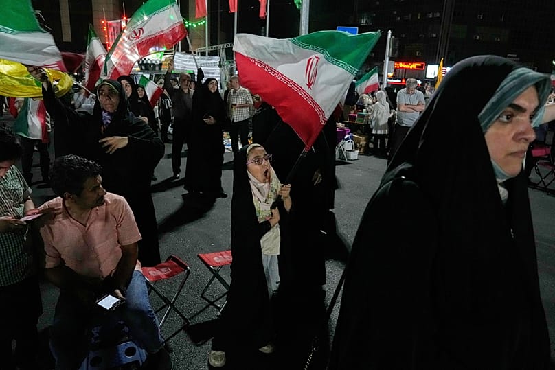 A girl waves an Iranian flag in a pro-government gathering in Tehran, Iran, Sunday, June 7, 2026. 