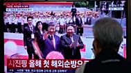 People watch a TV screen showing Chinese President Xi Jinping and North Korean leader Kim Jong.