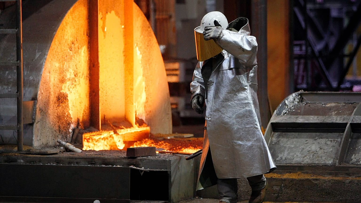 FILE. A worker walks next to a furnace at the ThyssenKrupp steel factory in Duisburg, Germany, Jan. 2020