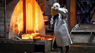 FILE. A worker walks next to a furnace at the ThyssenKrupp steel factory in Duisburg, Germany, Jan. 2020