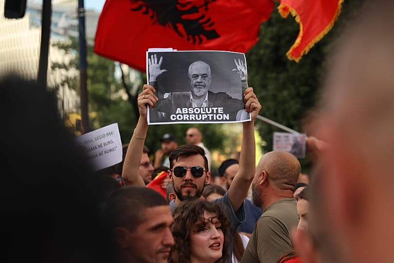 Protestujący z plakatem przedstawiającym premiera Ediego Ramę biorą udział w demonstracji w Tiranie, 6 czerwca 2026