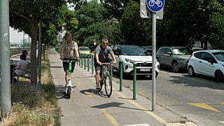 Un usuario de patinete y un ciclista en Budapest