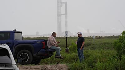 Arbeiter warten auf die Wiedereröffnung einer Straße, SpaceX testet derweil seine Starship-Megarakete in Starbase, Texas, 20. Mai 2026.