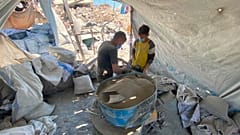 ورشة داخل خيمة حيث يتم طحن الإسمنت المتحجر لاستعماله في عملية البناء
