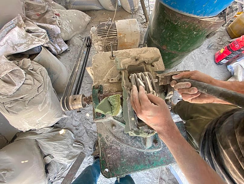 عملية تكسير الاسمنت المتحجر بوسائل بدائية لتحويله إلى مسحوق واستعمله في عملية البناء