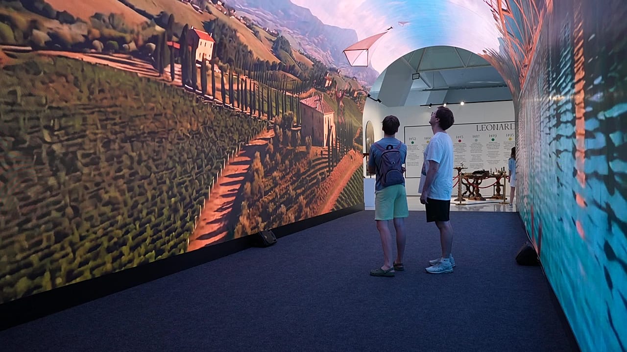 Los visitantes recorren un túnel de LED en la exposición.