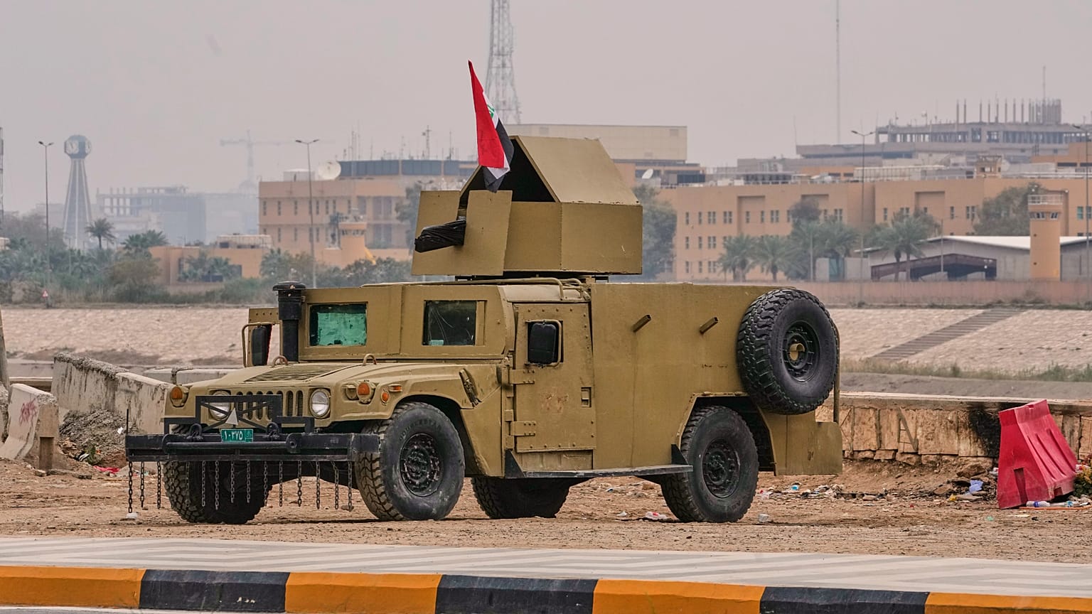 تم نشر مركبة هامفي مدرعة تابعة للجيش العراقي بالقرب من ضفاف نهر دجلة لحماية "المنطقة الخضراء" المحصنة التابعة للسفارة الأمريكية في بغداد، يوم السبت 14 مارس 2026. (صورة من وكال